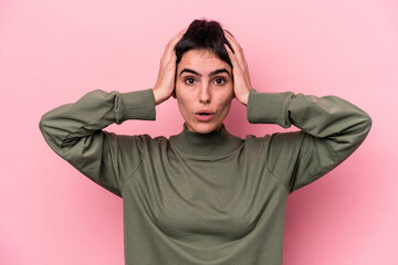 Young caucasian woman isolated on pink background being shocked, she has remembered important meeting.