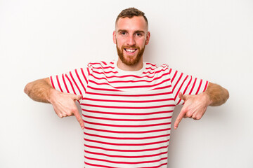 Young caucasian man isolated on white background points down with fingers, positive feeling.