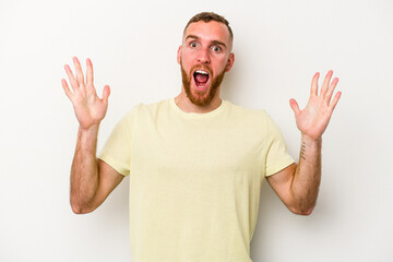 Young caucasian man isolated on white background celebrating a victory or success, he is surprised and shocked.