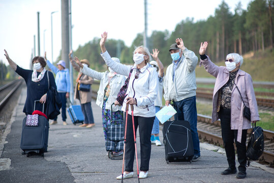 A Group Of Senior Friends In Face Masks On The Platform Waiting For A Train