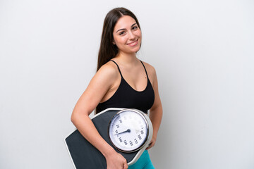 Young girl isolated on white background with arms at hip and holding weighing machine