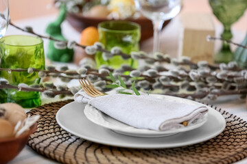 Stylish dinnerware and pussy willow branches on table served for Easter celebration