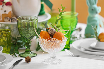 Bowl with Easter eggs and eucalyptus branch on served table