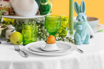 Obraz na płótnie Canvas Holder with Easter egg and eucalyptus branch on served table