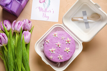 Plastic lunch box with tasty bento cake, greeting card and flowers on color background