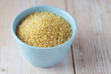 Dry uncooked bulgur in a ceramic bowl