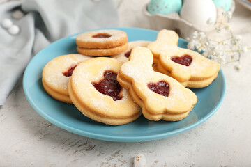 Plate with delicious Easter cookies on light background, closeup