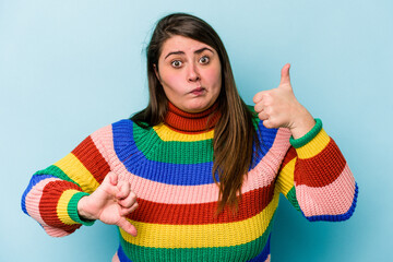 Young caucasian overweight woman isolated on blue background showing thumbs up and thumbs down, difficult choose concept