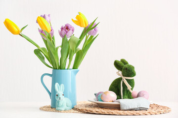 Plate with Easter bunny, eggs and tulip flowers on light background
