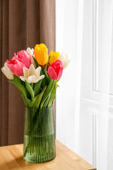 Beautiful bouquet of tulips in vase on table