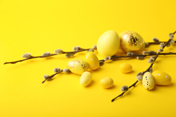 Painted Easter eggs and pussy willow branches on yellow background