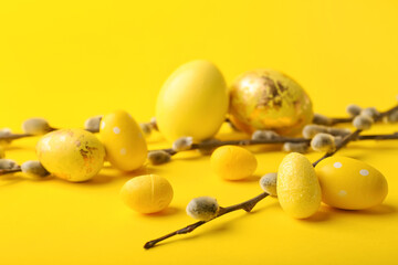 Painted Easter eggs and pussy willow branches on yellow background