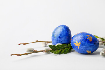 Painted Easter eggs and pussy willow branches on light background