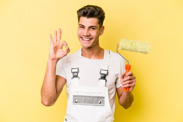 Young painter man isolated on yellow background cheerful and confident showing ok gesture.