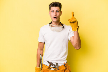 Young electrician caucasian man isolated on yellow background having some great idea, concept of creativity.