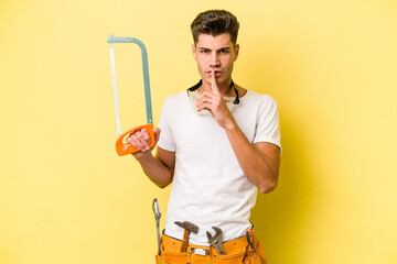 Young electrician caucasian man isolated on yellow background.keeping a secret or asking for...