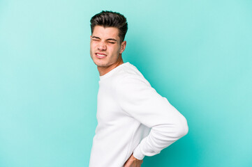 Young caucasian man isolated on blue background suffering a back pain.