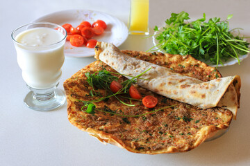 Turkish food: lahmacun, Turkish pizza, ayran, parsley, lemon, tomato.