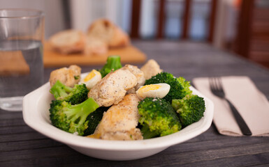 healthy appetizer of chicken pieces with broccoli and quail eggs in bowl for healthy lunch