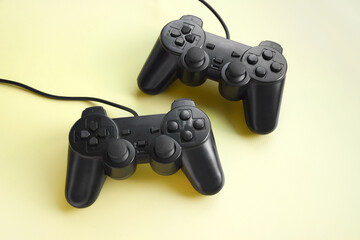 Two joystick gaming controller on yellow background.