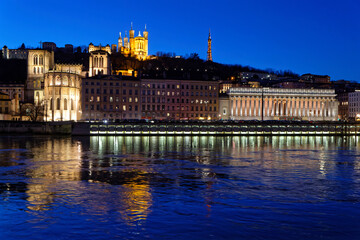 Fototapeta na wymiar LYON, FRANCE, February 19, 2022 : St-Jean Cathedral, Fourviere basilica and Court house reflect in the waters of Saone river at the blue hour.