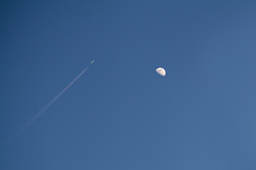 Plane flies against the background of the moon