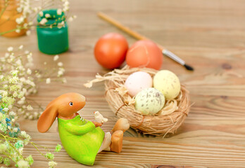 Easter bunny, eggs, paint and brush on a wooden table. Preparing for Easter