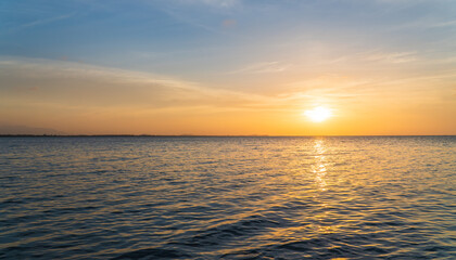 Sunset sky over sea in the evening with orange sunlight clouds
