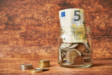 banconote e monete in euro in un barattolo
