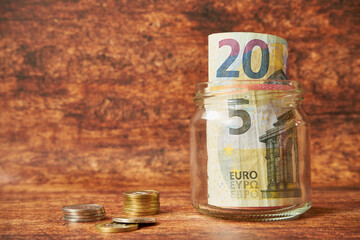 banconote e monete in euro in un barattolo