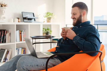 Man Watching Movie Online On Laptop Drinking Coffee At Home