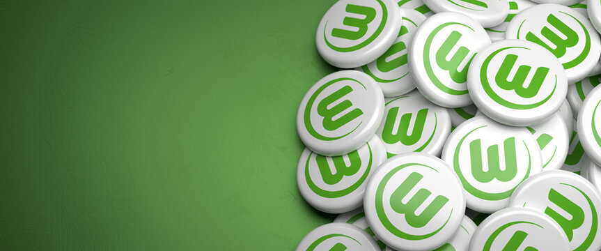 Logos of the German Soccer Club VfL Wolfsburg on a heap on a table. Copy space. Web banner format