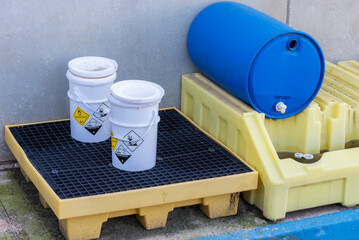 Containers with dangerous goods labels stored in a specific place for treatment and recycling.