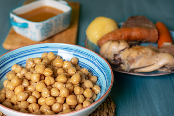 Cocido Madrileño, stew of chickpeas, vegetables, beef, chicken, chorizo and bacon typical of Madrid, served in separate dishes, soup, chickpeas and meat.