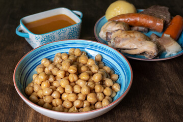 Cocido Madrileño, stew of chickpeas, vegetables, beef, chicken, chorizo and bacon typical of Madrid, served in separate dishes, soup, chickpeas and meat.