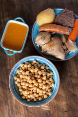 Cocido Madrileño, stew of chickpeas, vegetables, beef, chicken, chorizo and bacon typical of Madrid, served in separate dishes, soup, chickpeas and meat.