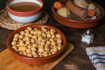 Cocido Madrileño, stew of chickpeas, vegetables, beef, chicken, chorizo and bacon typical of Madrid, served in separate dishes, soup, chickpeas and meat.