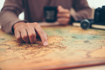 Fototapeta na wymiar Tourist planning vacation, holiday with the help world map. Man's hand marks route on map and using pins and rope. Travel concept.