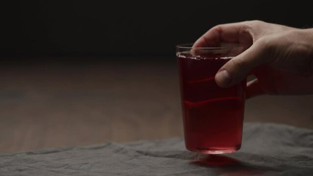 Slow motion man hand take berry drink in tumbler glass with copy space