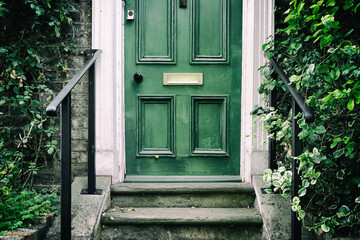 Traditional green-painted wooden door with traditional, victorian styled steps leading to the front of a terraced victorian house in a mews area of London. - obrazy, fototapety, plakaty