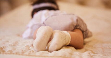 Small feet of a newborn baby in socks. The concept of motherhood and childhood.