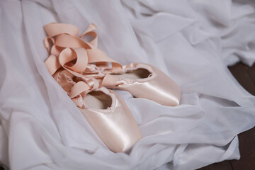  pointe shoes lie on a compressed white cloth.