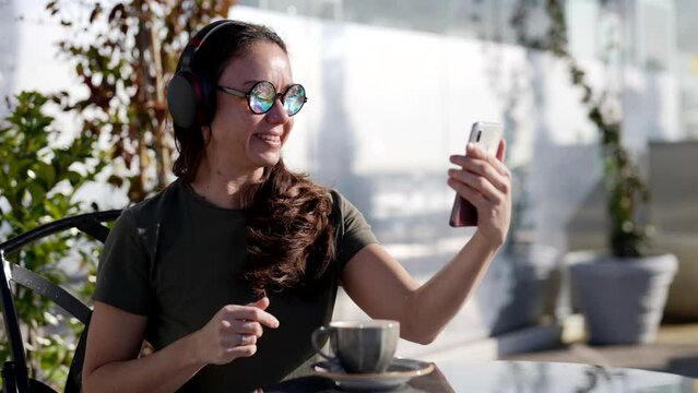 woman is communicating by video call or streaming in social media by smartphone and headphones