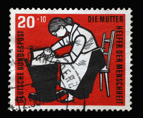 Stamp printed in Germany, shows Mother with baby cradle, circa 1956