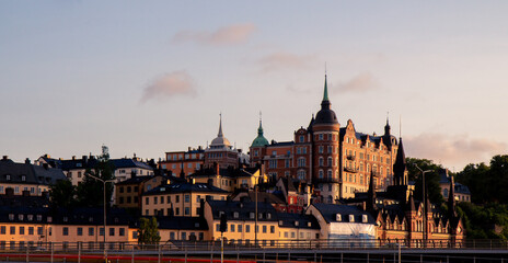 Fototapeta premium Stacked buildings on a hill in Stockholm Sweden during summer sunset