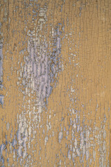 Peeling paint on the wall. Old wooden wall with cracked flaking paint. Rough painted surface with patterns of cracks and peeling. High resolution texture for background and design.