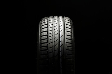 beautiful new summer tire on a black background. summer protector against aquaplaning and fuel...