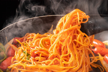 調理中のスパゲッティにケチャップを混ぜる