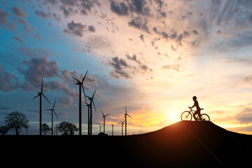 The concept of clean energy to save the world and the environment. Wind generators and cyclists