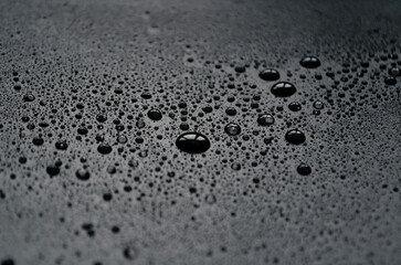 Drops of water on a dark matte surface close up, water blots, design concept from water on a matte background, macro photo of drops, glare in water drops, wet stains 